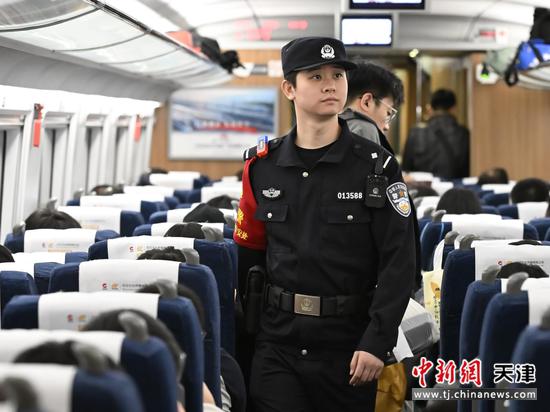 图为北京铁路公安局天津公安处乘警支队民警正在列车车厢内巡逻巡视,维护列车治安秩序。(北京铁路公安局天津公安处供图)