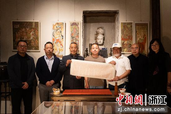 印水山房，以古法技艺打造的1:1比例复制的敦煌藏经洞洞窟内，众人合影。主办方供图