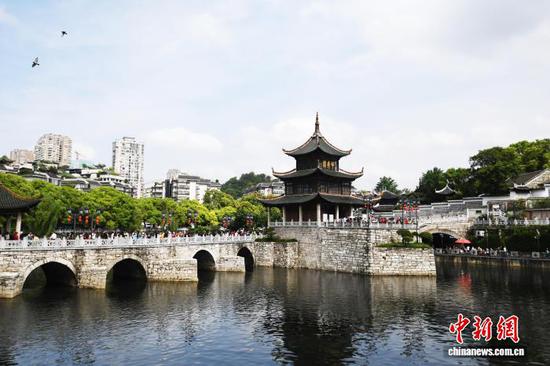 5月1日，“五一”假期第一天，贵阳市甲秀楼景区游人如织。甲秀楼位于贵阳市南明河上，以其400年的悠久历史和独特的建筑风格，吸引了众多游客前来赏景游玩、拍照打卡。图为远观甲秀楼。赵松 摄