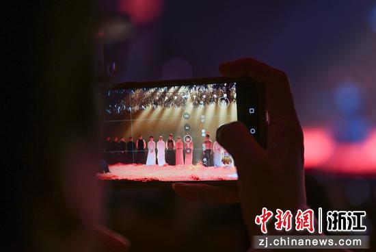 图为:观众拍摄杨丽萍和演员们返场表演。中新社记者 王刚 摄 图为:观众拍摄杨丽萍和演员们返场表演。中新社记者 王刚 摄