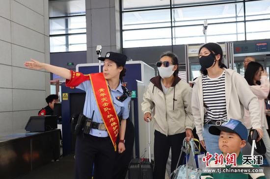 图为北京铁路公安局天津公安处天津西站派出所青年突击队民警正在为旅客指明乘车方向。(北京铁路公安局天津公安处供图)