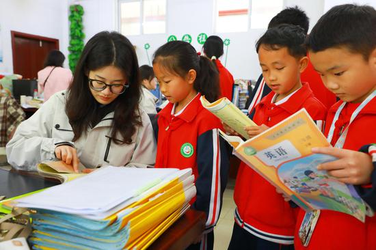 合肥工业大学研究生支教团成员正在检查学生英语单词背诵情况。谢达意摄