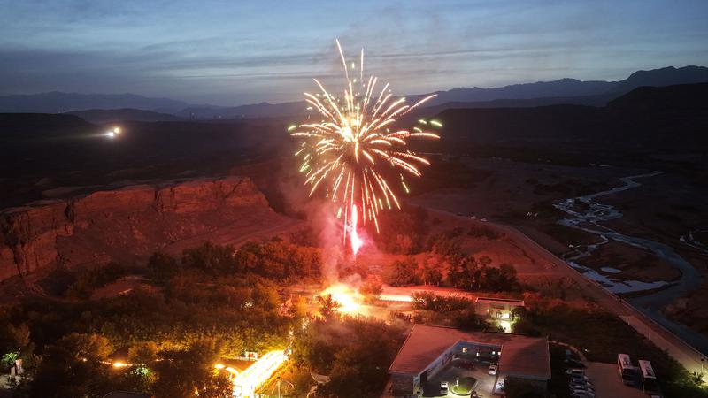 一束束烟花划破夜空，在红河谷上空绽放出金色、红色的绚丽花火。