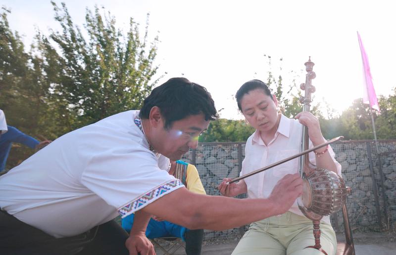 游客学习民族乐器。