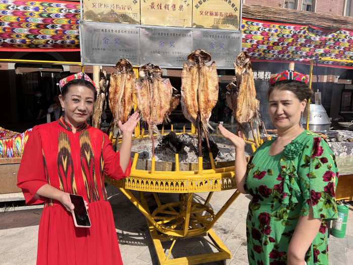 游客与烤鱼。杜婵 摄
