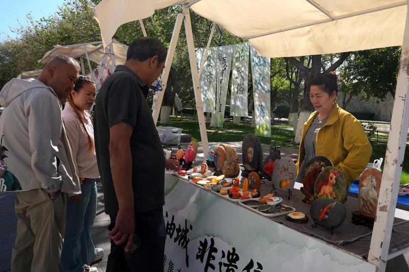 5月1日,游客在克拉玛依区文化步行街非遗集市上选购手工艺品。克拉玛依融媒记者 崔文娟 摄 5月1日,游客在克拉玛依区文化步行街非遗集市上选购手工艺品。克拉玛依融媒记者 崔文娟 摄