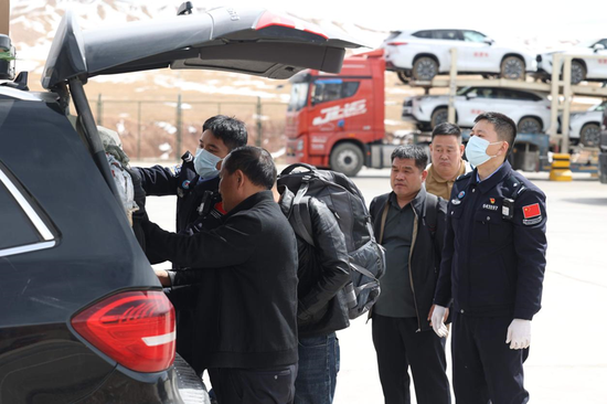 吐尔尕特出入境边防检查站民警对入境自驾游旅客进行车体检查。