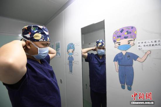 5月8日，贵阳市南明区人民医院手术室器械护士王颖在术前整理着装。赵松 摄