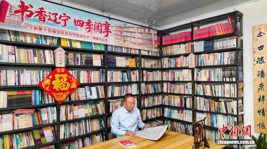 佟立在禾土农家书屋内看报纸。 受访者供图 佟立在禾土农家书屋内看报纸。 受访者供图