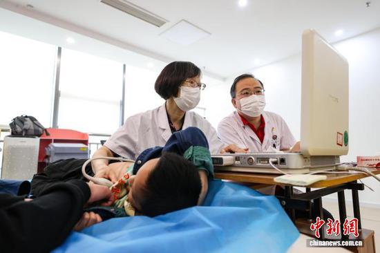 图为专家为儿童进行筛查。中新社记者 瞿宏伦 摄