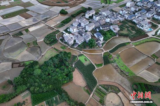 5月13日，航拍贵州省黔西南布依族苗族自治州兴义市万峰林水田。时下，万峰林水田迎来注水、插秧时节。从空中俯瞰，水田宛如天然“调色板”，与山峰、河流、村寨等融为一体，呈现出别样的田园风景。(无人机照片)中新社记者 瞿宏伦 摄