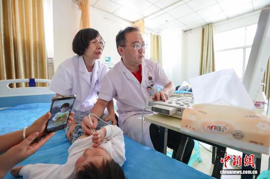 图为专家为儿童进行筛查。　中新网记者 瞿宏伦 摄