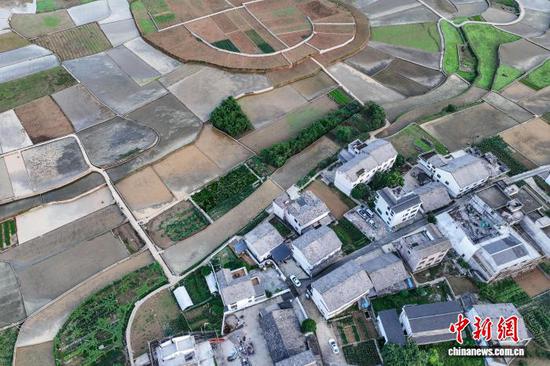 5月13日，航拍贵州省黔西南布依族苗族自治州兴义市万峰林水田。时下，万峰林水田迎来注水、插秧时节。从空中俯瞰，水田宛如天然“调色板”，与山峰、河流、村寨等融为一体，呈现出别样的田园风景。(无人机照片)中新社记者 瞿宏伦 摄