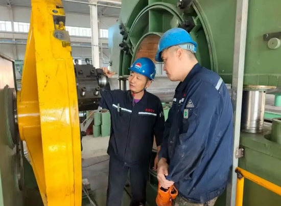 熊兆军（左）正在教授徒弟设备维修技巧。古再丽努尔·吾甫尔 摄e