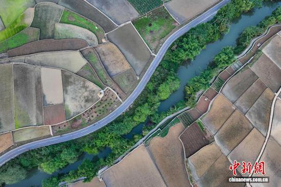 5月13日，航拍贵州省黔西南布依族苗族自治州兴义市万峰林水田。时下，万峰林水田迎来注水、插秧时节。从空中俯瞰，水田宛如天然“调色板”，与山峰、河流、村寨等融为一体，呈现出别样的田园风景。(无人机照片)中新社记者 瞿宏伦 摄