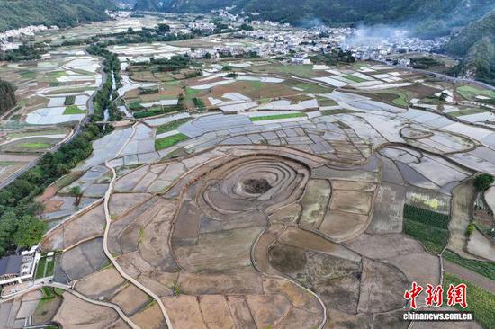 5月13日，航拍贵州省黔西南布依族苗族自治州兴义市万峰林水田。时下，万峰林水田迎来注水、插秧时节。从空中俯瞰，水田宛如天然“调色板”，与山峰、河流、村寨等融为一体，呈现出别样的田园风景。(无人机照片)中新社记者 瞿宏伦 摄