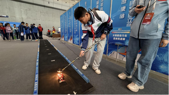 乌鲁木齐市109中学七年级学生胡耀祖正在进行太阳能动力车竞速赛。高楠 摄