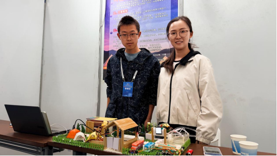 魏升（左一），介绍作品《那拉提生态营地——智慧露营管理系统》。高楠 摄