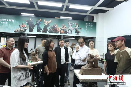 图为天津泥人张彩塑大师班现场,天津美术学院教授景育民(右四)与学员交流泥塑创作心得。 记者 周亚强 摄 图为天津泥人张彩塑大师班现场,天津美术学院教授景育民(右四)与学员交流泥塑创作心得。 记者 周亚强 摄