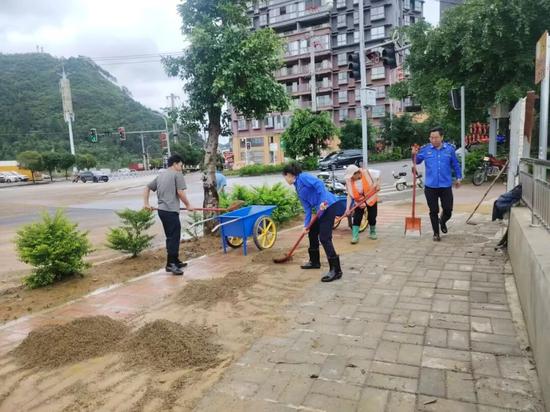 边阳镇党员干部清理路上积水淤泥（边阳镇供图）