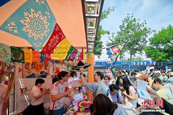 图为民众在拉美国家展位与留学生互动。中新社记者 佟郁 摄 图为民众在拉美国家展位与留学生互动。中新社记者 佟郁 摄