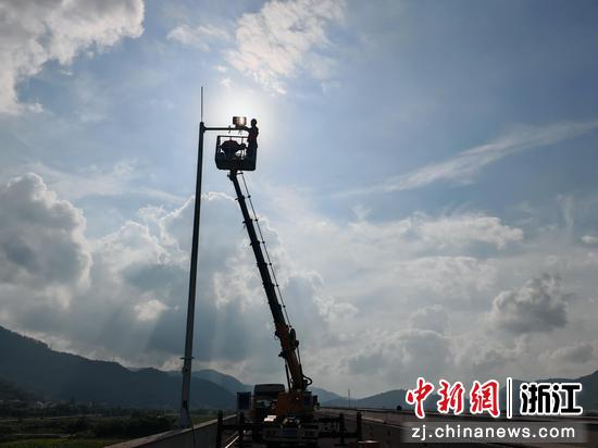 技术人员在瑞苍高速沿线安装AI智能摄像机。林江 供图 技术人员在瑞苍高速沿线安装AI智能摄像机。林江 供图