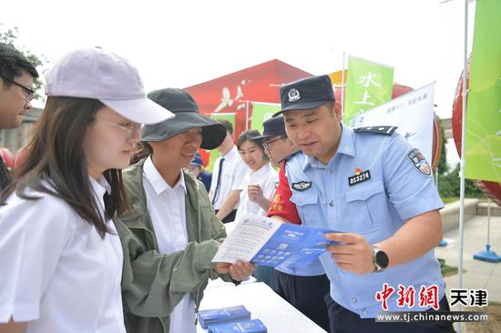 图为北京铁路公安局天津公安处民警正在向活动现场的群众发放宣传单,并耐心解答群众关心的法律问题。(北京铁路公安局天津公安处供图) 图为北京铁路公安局天津公安处民警正在向活动现场的群众发放宣传单,并耐心解答群众关心的法律问题。(北京铁路公安局天津公安处供图)