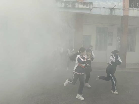 图为全体师生快速通过烟雾区域。覃小红 摄 图为全体师生快速通过烟雾区域。覃小红 摄