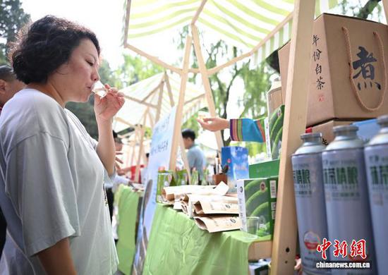 5月21日是国际茶日，“干净黔茶·全球共享”5·21国际茶日主题活动在北京北海公园拉开帷幕。活动上，贵州茶企对贵州茶进行推介，吸引游园市民品尝贵州生态茶以及抹茶产品。图为市民在现场品茶。中新社记者 赵文宇 摄