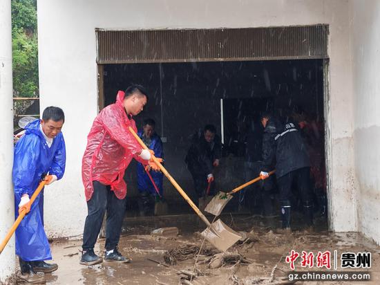 与群众一起清扫受灾房屋