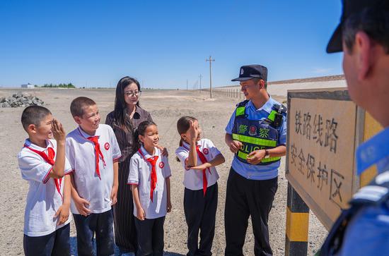 民警在铁路沿线涵洞前向学生们现场讲解铁路安全注意事项。谢仁古力·托呼提 摄
