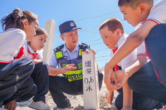 民警在铁路沿线涵洞前向学生们现场讲解铁路安全注意事项。谢仁古力·托呼提 摄