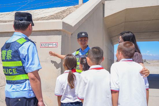 民警在铁路沿线涵洞前向学生们现场讲解铁路安全注意事项。谢仁古力·托呼提 摄