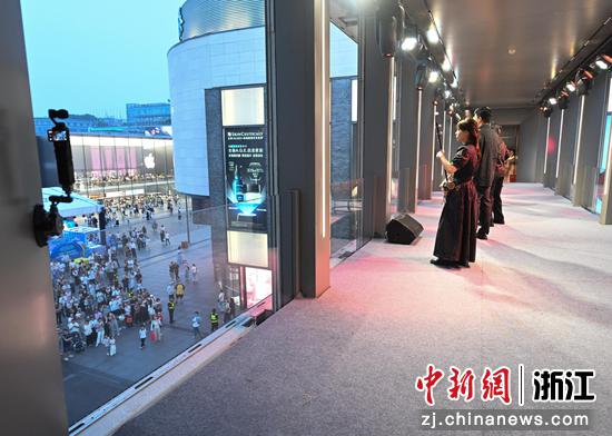 图为：浙大学子在西子廊桥内表演《龙腾虎跃》吸引桥下游人驻足观看。中新社记者 王刚 摄