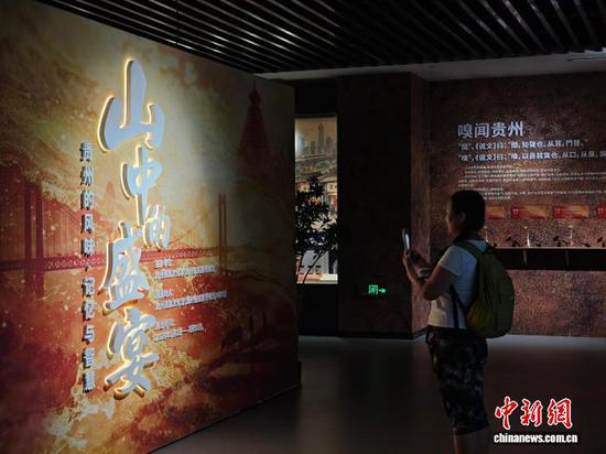 5月26日，游客在位于贵阳市南明区的贵州省民族博物馆内观赏“山中的盛宴：贵州的风味、记忆与智慧”展览。展览以饮食文化为切入点，围绕食物的流动、技艺的互学、共食的生成、记忆的沉淀、价值的内化与当代的回响六条线索展开叙事，系统呈现贵州多民族在长期交往交流交融中共同塑造的风味体系、生活智慧与文化精神，并通过调动观众的味觉、听觉、触觉、视觉与嗅觉，构建一个多维度、沉浸式、可感知的展览现场。图为5月26日，游客在展厅内拍照打卡。石小杰 摄