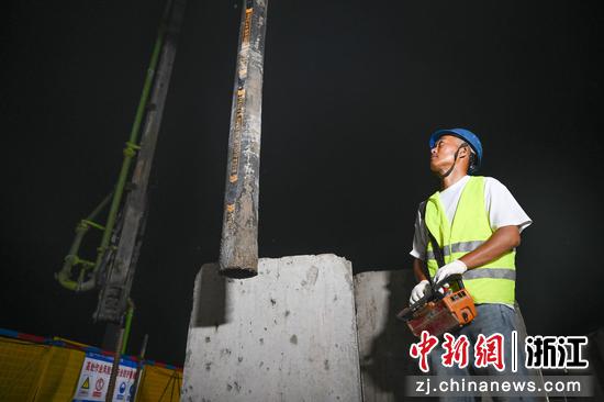 
图为：跨百步亭港T构连续梁合龙施工现场，工人控制浇筑设备。中新社记者 王刚 摄