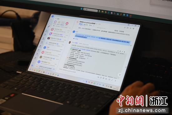 图为：王明雷展示其和“数字员工”沟通工作的记录。中新社记者 王刚 摄