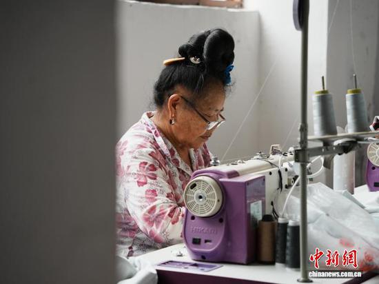图为在侯昌菊服装车间工作的苗族妇女。记者 周燕玲 摄 图为在侯昌菊服装车间工作的苗族妇女。记者 周燕玲 摄