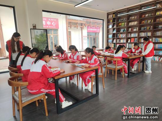 赫章县金银山书院里，志愿者为读书会活动的孩子们解答问题。 刘虹艳 摄