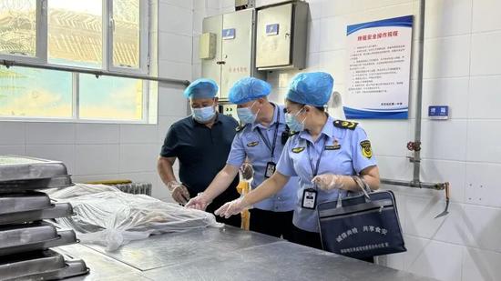 执法人员在考点食堂检查食材。努尔古再丽 摄