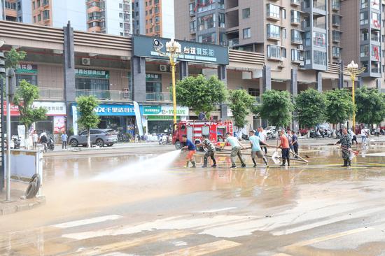 党员干部正在对受灾路段进行路面冲洗
