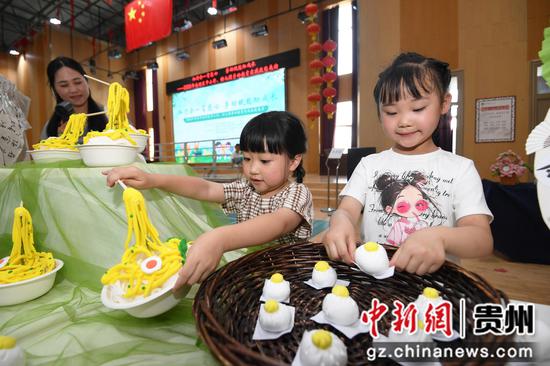 6月5日，贵阳市南明区苗苗幼儿园的小朋友正在劳动教育实践技能展演活动现场展示用粘土制作的面点美食。