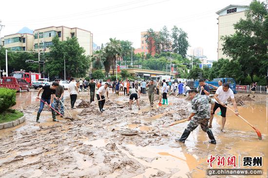 党员干部在县一小路段清理积水和淤泥。