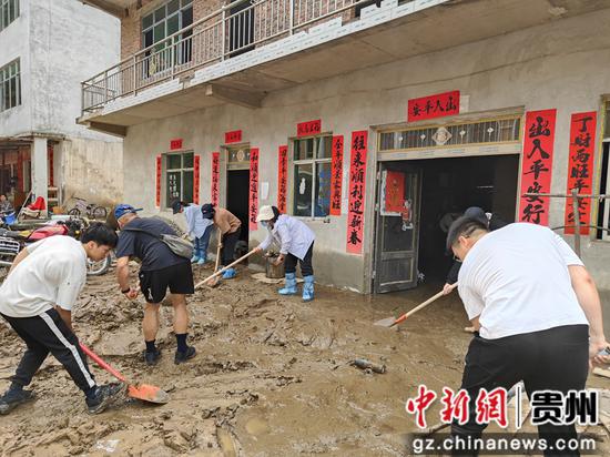 帮助谷江村受灾群众清淤。