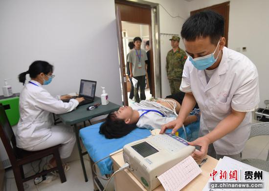 6月15日，在贵阳市南明区征兵体检站，医护人员正在为适龄应征青年进行心电图检测。