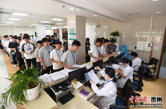6月15日，在贵阳市南明区征兵体检站，工作人员正对适龄应征青年信息进行核对。