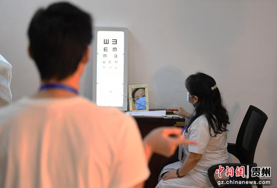 6月15日，在贵阳市南明区征兵体检站，医护人员正为适龄应征青年进行视力检测。
