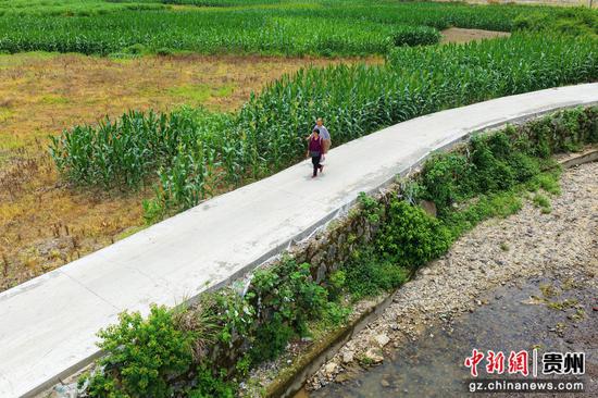 在剑河县南明大坝，村民走在修复一新机耕道上。吴麟钦 摄