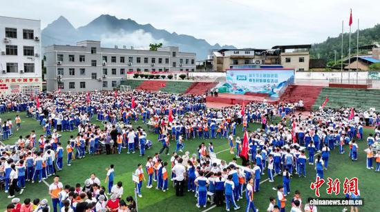 图为6月18日，贵州省罗甸县第二小学开展“2026端午节主题团建暨师生民俗体验”活动，学生、家长和教师一起包粽子。史传鸿 摄