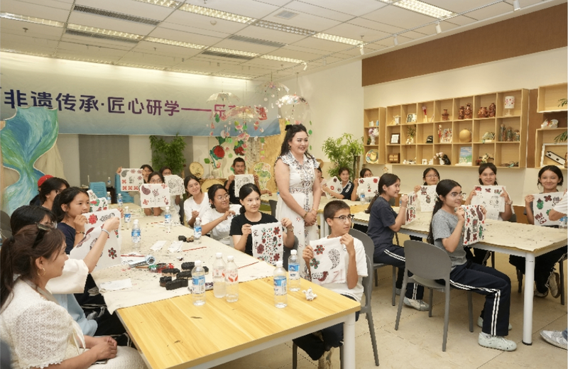 非遗传承人带领克拉玛依学生制作展示国家级非遗——模戳印花布。克拉玛依融媒体记者 崔文娟 摄